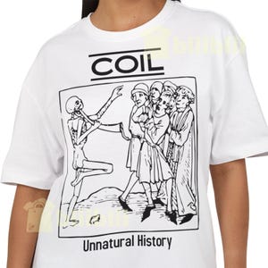 May include: White t-shirt with a black graphic. The graphic includes the word "COIL" above a black and white illustration of a skeleton and figures. The text "Unnatural History" is below.