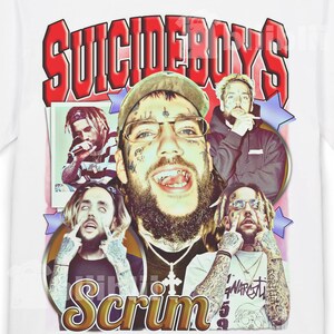 May include: White t-shirt with a graphic design featuring the text "SUICIDEBOYS" in red and portraits of several people. The word "Scrim" is also visible in a gold colour. The design includes stars and a vintage aesthetic.