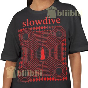 May include: Black t-shirt with the word "slowdive" in red, above a red geometric design. The design is a maze-like pattern with a central shape. A casual wear item.