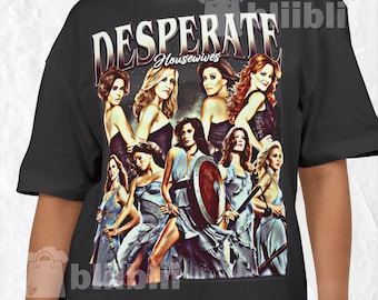 May include: Black t-shirt featuring a graphic of the cast of Desperate Housewives. The design includes the show's title in a stylized font above images of the actresses in various poses. The shirt is a crew neck.
