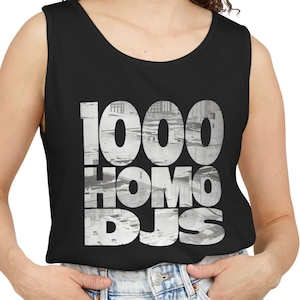 Puede incluir: Una camiseta sin mangas de color negro con un gran estampado gráfico en la parte delantera. El texto 1000 HOMO DJS aparece en letras negritas y grandes, con un patrón fotográfico de paisaje urbano en escala de grises dentro de los caracteres.