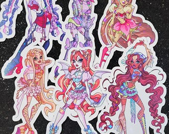 May include: Five colorful stickers featuring cartoon characters with glitter accents. Each sticker features a different character with unique hairstyles, clothing, and accessories. The characters are all female and have a whimsical, fantasy-inspired aesthetic.