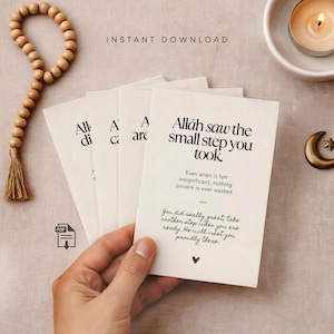 Könnte beinhalten: Cremefarbene Karten mit schwarzem Text, darunter der Satz "Allah sah den kleinen Schritt, den du getan hast." Eine hölzerne Gebetskette und eine kleine Kerze sind ebenfalls zu sehen.