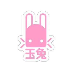Könnte beinhalten: Ein pinkfarbener Aufkleber mit einem stilisierten Hasen-Design und den chinesischen Schriftzeichen für "Jade-Kaninchen" darunter. Der Hase hat große Ohren und zwei weiße Punkte als Augen. Der Aufkleber hat einen weißen Rand.