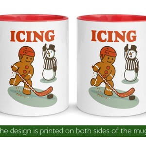 May include: White ceramic mug with a red interior and handle. The mug features a gingerbread man playing hockey with the word "ICING" above the image. A snowman referee is also present.