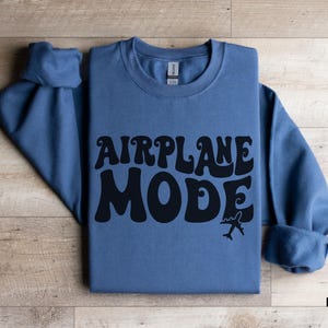 May include: Indigo blue sweatshirt with the text "AIRPLANE MODE" in black, stylized lettering. A small airplane graphic is below the text.