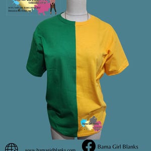 May include: A green and yellow t-shirt with a split design. The left side of the shirt is green and the right side is yellow. The shirt is on a mannequin. The text "Bama Girl Blanks" is on the shirt.