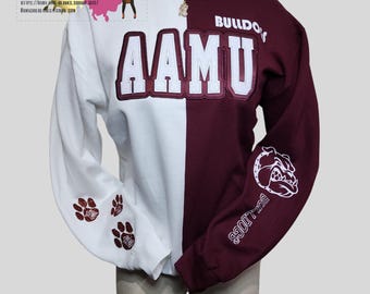 May include: A white and maroon split-colour sweatshirt with the words "AAMU" and "BULLDOGS" on the front. The sleeves have a maroon paw print design.