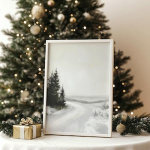 Peut inclure: Peinture encadrée d'un paysage hivernal avec une route enneigée et des arbres à feuilles persistantes. L'œuvre est dans un cadre blanc et est posée sur une surface blanche, avec un sapin de Noël et un cadeau emballé en arrière-plan.
