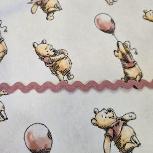 Kubuś Puchatek w flaneli. Spersonalizowany ochraniacz na siedzenie wózka sklepowego dla niemowląt, zaprojektowany z myślą o bezpieczeństwie i komforcie Twojego malucha.