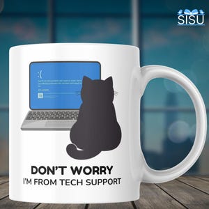 Könnte beinhalten: Weiße Keramiktasse mit einer schwarzen Katzen-Silhouette und dem Text "DON'T WORRY I'M FROM TECH SUPPORT." Die Tasse zeigt einen blauen Bildschirm mit einem traurigen Gesicht und einer Laptop-Grafik.