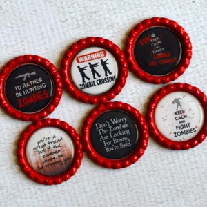 May include: Set of ten red bottle caps with various zombie-themed designs. The designs include "I'd rather be hunting zombies", "Warning Zombie Crossing", "Run Keep Calm Carry Lobes Are Coming", "You're a great friend but if the zombies choose us I'm tripping you", "Don't Worry The Zombies Are Looking For Brains You're Safe", and "Keep Calm And Fight Zombies".