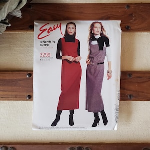 May include: A sewing pattern for two dresses, one red and one gray, with the text "Easy Stitch 'n Save" and "3299" on the front.