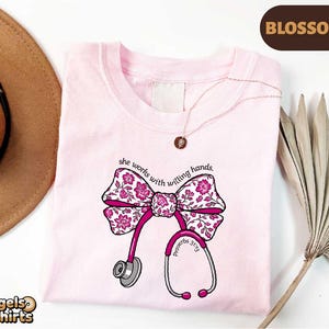 Könnte beinhalten: Eine weiße Keramik-Tasse mit schwarzem Henkel und dem Text "But First, Coffee" in handschriftlichem Stil. Die Tasse steht auf einer weißen Oberfläche. Die Tasse ist etwa 10 cm hoch.