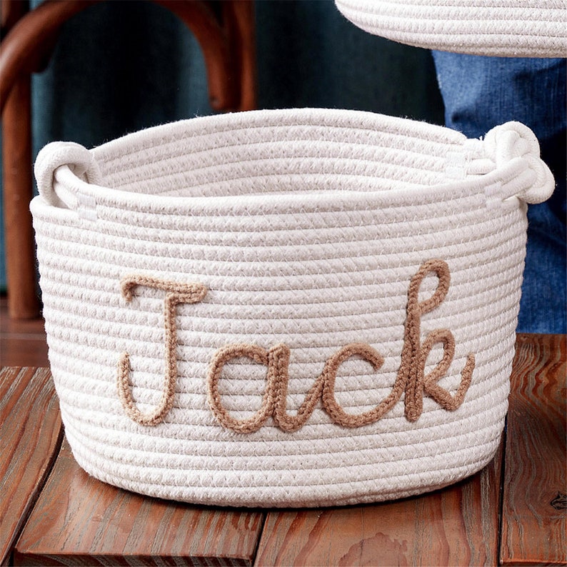 May include: White rope storage basket with the name "Jack" embroidered in brown thread.