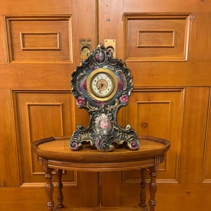 An antique late 19th century porcelain / ceramic ornate wind up mantle clock.