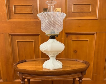 Antique ornate milk glass oil lamp with opalescent ruffle shade.