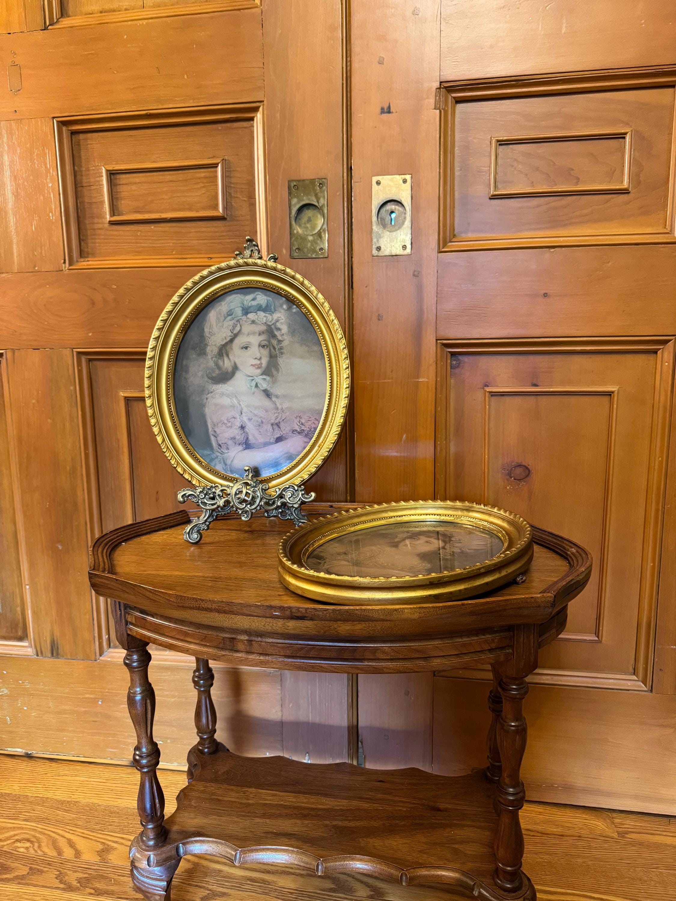 A pair of antique late 19th century prints of the daughters of the Marquis of Blandford in gilded oval wood frames under glass