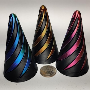 May include: Three small, cone-shaped objects with a black base and iridescent, swirling patterns in blue, gold, and pink.