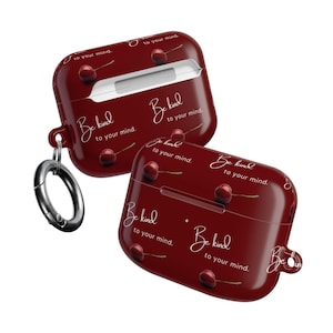 May include: Two maroon AirPod cases with a cherry design and the text "Be kind to your mind." The cases have a glossy finish and a silver carabiner clip. The design includes illustrations of cherries.