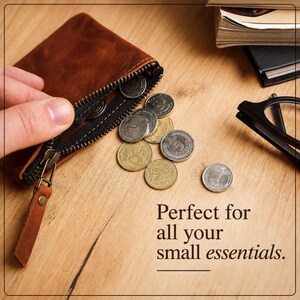 Pu&ograve; includere: Un portafoglio in pelle marrone con cerniera, aperto per rivelare diverse monete. Il portafoglio &egrave; su una superficie di legno, con il testo "Perfect for all your small essentials."