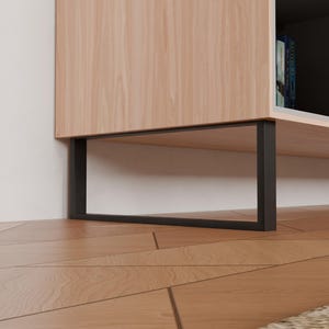 Può includere: Un mobile moderno in legno con finitura a venatura chiara. Il mobile ha una struttura e gambe in metallo nero. Poggia su un pavimento in legno con un motivo geometrico. Il mobile ha una mensola aperta.