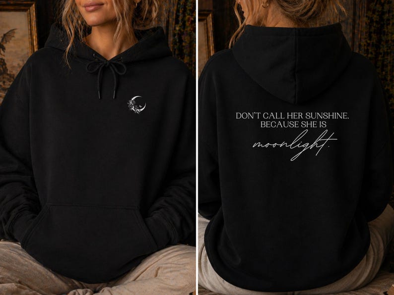 K&ouml;nnte beinhalten: Schwarzer Kapuzenpullover mit Kordelzug und Vordertasche. Auf der Vorderseite befindet sich ein kleiner Mond und ein Blumendesign. Auf der R&uuml;ckseite des Hoodies steht der Text "DON'T CALL HER SUNSHINE. BECAUSE SHE IS moonlight."