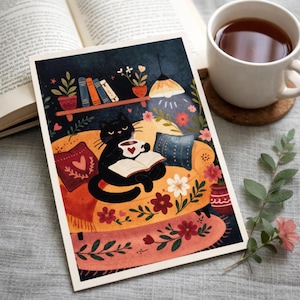 May include: A whimsical art print featuring a black cat relaxing on a yellow sofa, reading a book, and holding a cup of tea. The illustration includes a bookshelf, flowers, and a warm, inviting atmosphere. A cup of tea and an open book are also in the image.