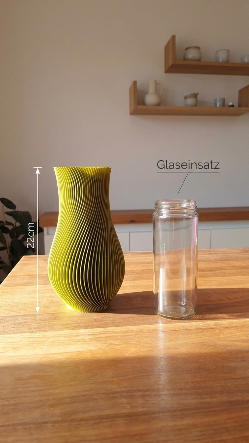 May include: A lime green vase with a vertical ribbed texture and a height of 22 cm, accompanied by a clear glass insert labeled Glaseinsatz. The vase has a curved, tapered silhouette and a wide opening at the top, designed to hold the glass cylinder.