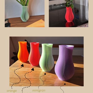 May include: A collection of four 3D-printed vases with a vertical ribbed texture and a curved silhouette. The vases are available in orange, neon pink, mint green, and lavender purple. The text 'by Japi Design' is visible at the bottom right.