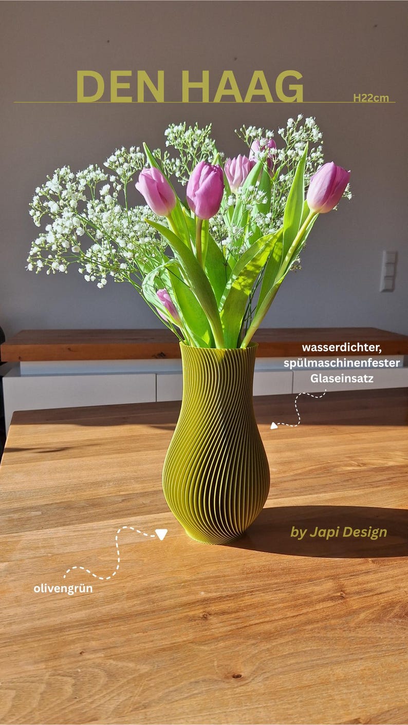 May include: An olive green vase with a textured, spiraled exterior design, labeled Den Haag, measuring 22cm in height. The vase contains a bouquet of pink tulips and white baby's breath flowers, and includes a waterproof, dishwasher-safe glass insert.