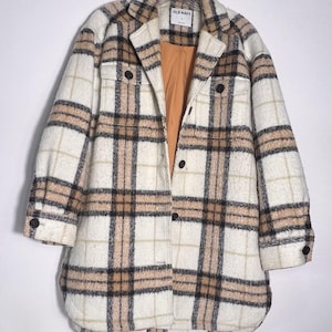 May include: A white ceramic mug with a black handle and the text "But First, Coffee" in a bold, black font. The mug is set against a neutral background, highlighting its simple design.