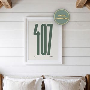 Könnte beinhalten: Ein gerahmter Druck mit der Zahl "407" in Dunkelgrün auf hellem Hintergrund. Der Druck hängt über einem Bett mit weißer Bettwäsche. Ein "Digitaler Download"-Aufkleber ist sichtbar.
