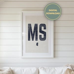 Op de afbeelding: Een ingelijste print met de letters "MS" in een donkerblauwe, getextureerde lettertype, met een bijpassende omtrek van de staat Mississippi. De print hangt aan een witte muur, met een "Digitale download" sticker rechtsboven.