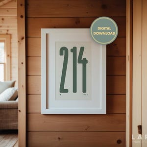 May include: A framed print with the number "214" in a dark teal color. The print is in a white frame and is hanging on a wooden wall. A "DIGITAL DOWNLOAD" sticker is on the top right corner of the frame.