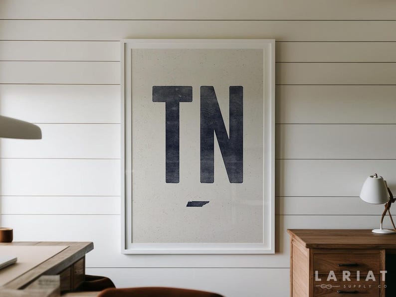 Pu&ograve; includere: Una stampa artistica incorniciata con le grandi lettere blu navy scuro TN centrate su uno sfondo color crema chiaro con una sottile trama punteggiata. Sotto le lettere si trova una piccola silhouette blu navy a tinta unita dello stato del Tennessee.
