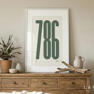 Könnte beinhalten: Gerahmter Kunstdruck mit der Zahl "786" in dunkelgrüner Schrift auf cremefarbenem Hintergrund. Das Kunstwerk wird auf einer Holzkommode mit einer Topfpflanze, Vasen und Treibholz präsentiert.