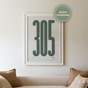 May include: A framed print featuring the number "305" in a bold, green font against a light gray background. The print is in a white frame and hangs above a beige sofa with brown pillows. A "DIGITAL DOWNLOAD" sticker is in the top right corner.