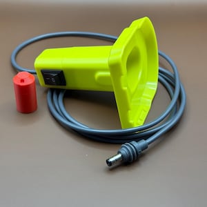 May include: A yellow and gray electric device with a cord and a red plug. The device has a switch and a round opening.