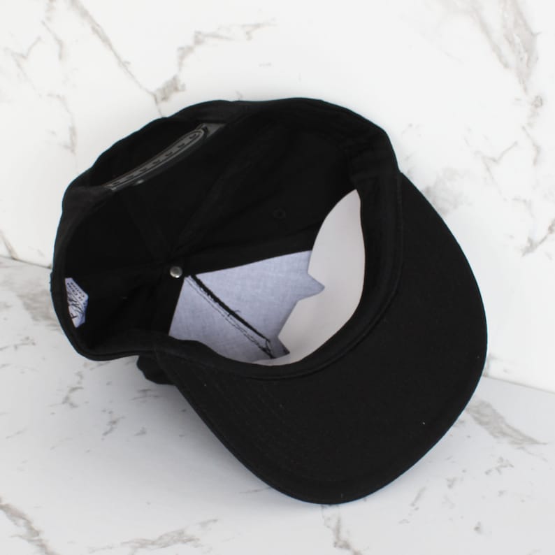 May include: A black baseball cap with a curved brim. The cap is made of a soft, cotton fabric and has a classic, casual style.