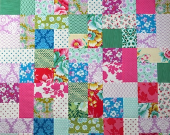 Peut inclure: Une courtepointe patchwork aux couleurs vives, composée de divers tissus à motifs floraux et géométriques. Le motif est fait de nombreux carrés et rectangles, avec des roses, bleus, verts et rouges. Le design comprend des pois, des imprimés floraux et des motifs géométriques.