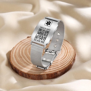 Puede incluir: Una pulsera de metal plateado con un símbolo médico y un código QR que dice "HEALTH INFO" y "SCAN ME".