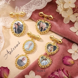 May include: Four gold-toned metal photo brooches with bow-shaped tops. Two brooches feature single oval or heart-shaped frames with portraits, while two feature double-linked frames. The text "Andrews" and "Style E" is printed on the surface.