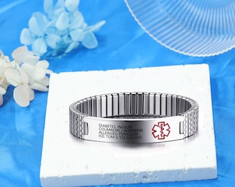 May include: A silver medical alert bracelet with a red medical symbol and engraved text: "Diabetes, Insulin, Coumadin/Warfarin, Allergies: Penicillin, ICE: Tom G 555-555-5555".