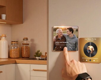 May include: A smart home device displays a photo of a father and son with the text "Father and Daughter". A gold-colored device shows a vinyl record design with the text "You Raise Me Up". The devices are mounted on a beige wall.