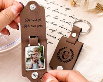 May include: Two brown leather keychains with silver key rings. One features a photo and the text "Drive safe, We love you." The other has the name "Chester" within a laurel wreath.