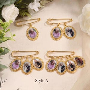 May include: Gold-toned brooch pins with oval photo pendants. Each pin features a large safety pin design with multiple pendants. The pendants display portraits of people in ornate, filigree frames. The text "Style A" is visible.