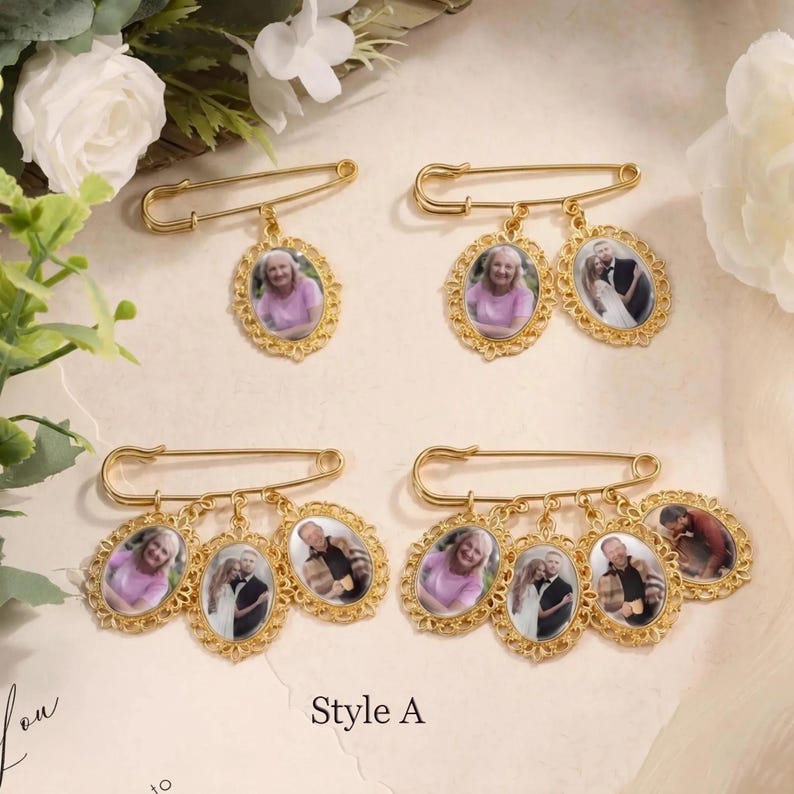 May include: Gold-toned brooch pins with oval photo pendants. Each pin features a large safety pin design with multiple pendants. The pendants display portraits of people in ornate, filigree frames. The text "Style A" is visible.