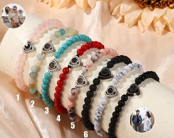 Puede incluir: Ocho pulseras diferentes con cuentas de varios colores y un dije de corazón plateado con una foto oculta en su interior. Las pulseras están numeradas del 1 al 8.