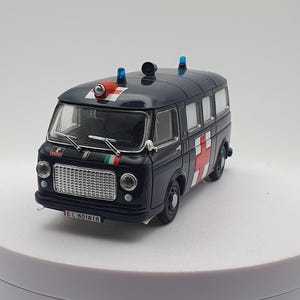 Op de afbeelding: Een donkerblauw vintage ambulance model met rode kruizen en witte accenten. Het model heeft een gedetailleerde grille, koplampen en zwaailichten op het dak. De Italiaanse vlag is aan de voorkant te zien.